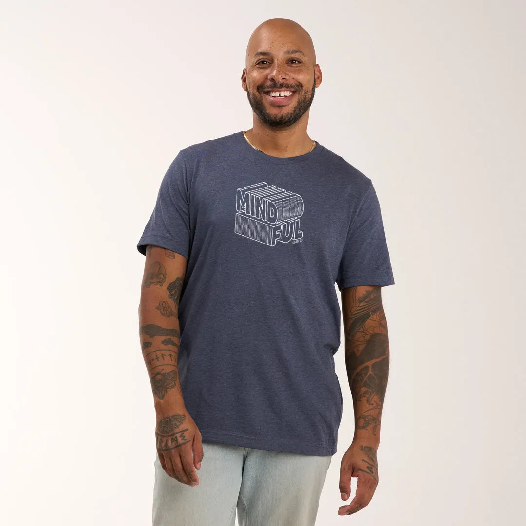 A model wearing Mindful Supply's Mind Ful Tee in heather navy with light trousers.