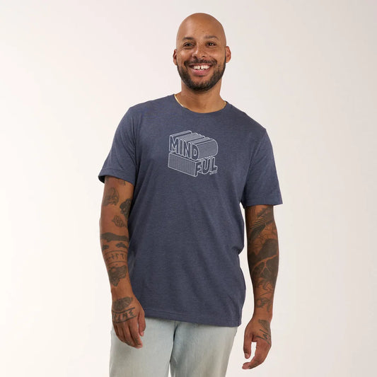 A model wearing Mindful Supply's Mind Ful Tee in heather navy with light trousers.