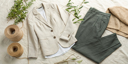 An outfit from an affordable ethical clothing brand, including a linen blazer, green pants, and a sweater.